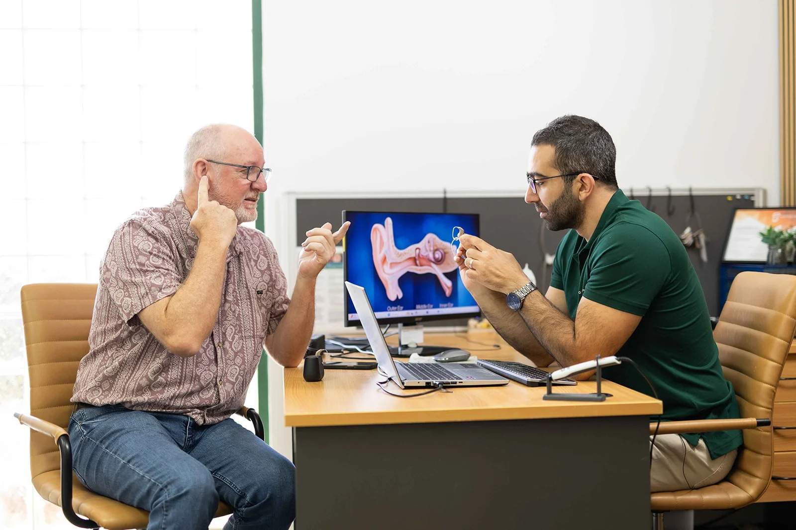 Man getting his first hearing aids Man getting his first hearing aids